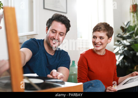 Paar zu Hause sitzen, hören Sie alte Aufzeichnungen Stockfoto