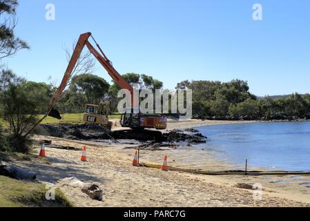 Hydraulische Bagger oder Bagger Kran im Wasser in Australien, Coffs Harbour als am 25. Juni 2018. Mit schweren Maschinen in Aktion bei der Arbeit vor Ort. Stockfoto