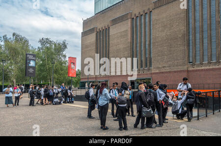 Zwei Gruppen von Schülern mit ihren Lehrern wartet der Tate Modern Art Gallery in London zu geben. Manche tragen Arbeitsblätter. Stockfoto
