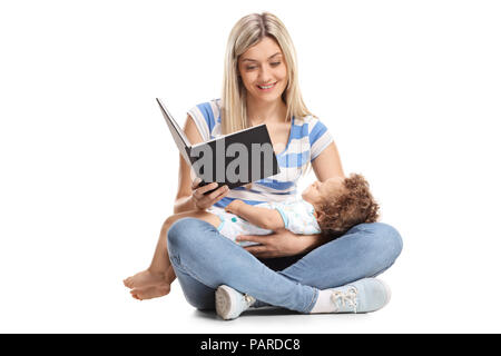 Junge Mutter ein Buch lesen, mit Ihrem baby boy Schlafen in ihren Schoß auf weißem Hintergrund Stockfoto