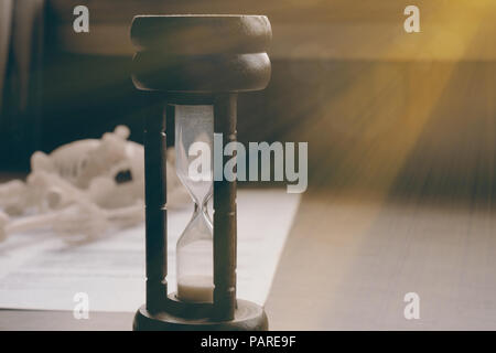 Nahaufnahme von Vintage Sanduhr auf den Tisch. Schwaches Licht. Vintage Style. Stockfoto