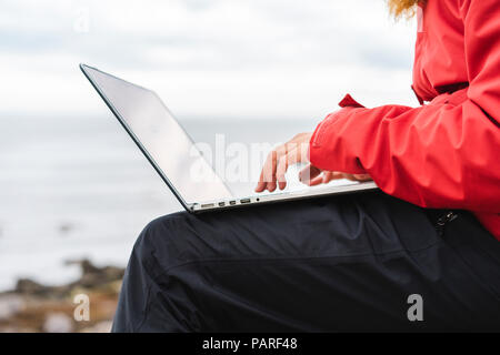 Island, North Island, Mann mit Laptop im Freien, Teilansicht Stockfoto