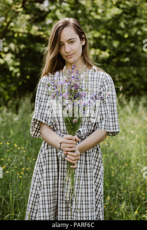 Italien, Venetien, junge Frau mit Bündel von wilden Blumen Stockfoto