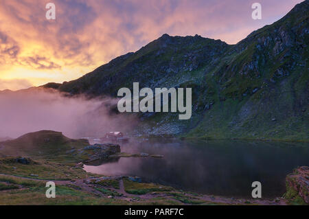 Sonnenaufgang am Balea See in einem nebligen Morgen, die Karpaten in Rumänien Stockfoto