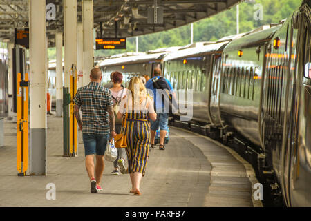 Fahrgäste entlang eine Plattform in Swansea Station ihren Zug nach. Stockfoto