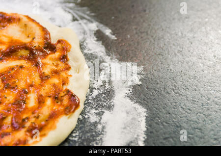 Pizza vorbereiten, in der Nähe der Pizza Teig mit Tomatensauce. Stockfoto