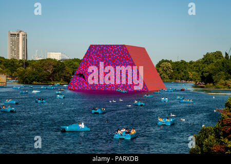 Menschen in Tretboote auf dem Serpentine mit "Die mastaba "Schwebende Skulptur im Hintergrund, Hyde Park, London, England Stockfoto