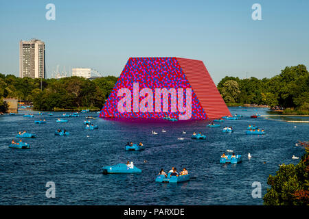 Menschen in Tretboote auf dem Serpentine mit "Die mastaba "Schwebende Skulptur im Hintergrund, Hyde Park, London, England Stockfoto