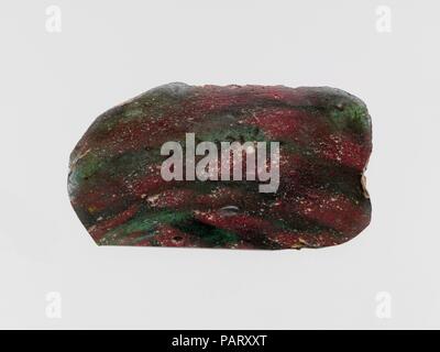 Glas Mosaik inlay Fragment. Kultur: Roman. Abmessungen: Insgesamt: 1 1/8 x 2 1/8 in. (2,9 x 5,4 cm). Datum: Ende 1.Jh. v. Chr. - frühe 1. Jh. N.CHR.. Transluzent blau grün und undurchsichtige Ziegelrot. Flache, rechteckige Plakette, mit zwei langen geraden Seite und abgerundete Ecken; unregelmäßige tooling Gedankenstriche auf der Unterseite. Marmor Mosaik Muster in Blau Grün Masse mit mehreren roten Streifen. Zerfranste Kanten; Poliert obere Seite; Vertiefungen der Oberfläche blasen; Mattierung und einige Löcher auf der Unterseite; irisierende Verwitterung auf die meisten Kanten, sondern Teil einer langen Seite flach geschliffen. Transluzent blau grün und opaq Stockfoto