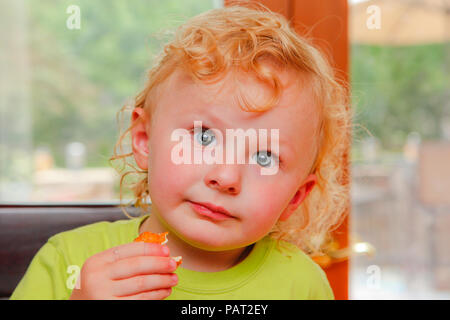 Niedliche Kind essen einen Snack Stockfoto