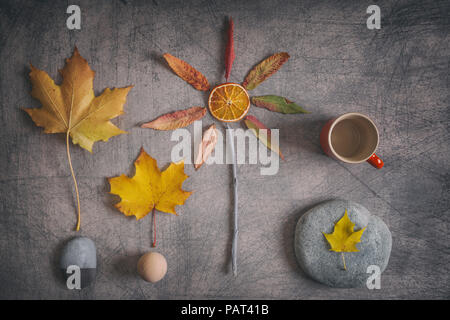 Kreative herbstliche Komposition aus ein paar einfachen Objekten in warmen orange-gelben Farbtönen auf rustikalen Hintergrund Stockfoto
