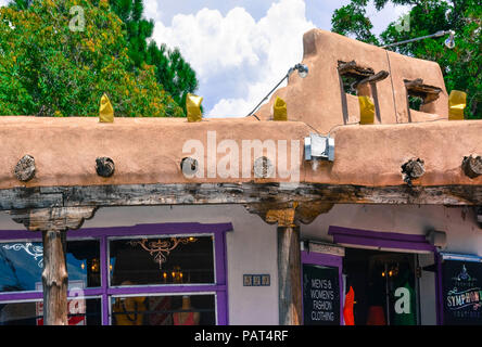 Eine alte verwitterte und funky Adobe Gebäude mit vigas und Portico verkauft für Männer und Frauen Mode und Geschenke in der Altstadt von Albuquerque, NM Stockfoto