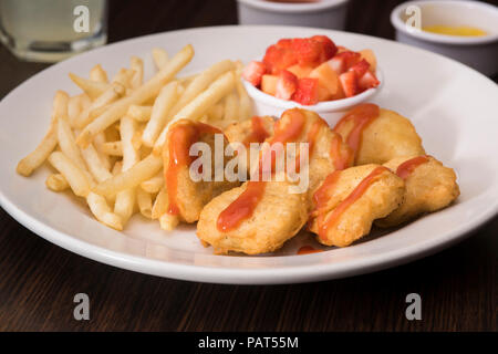 Nuggets und Pommes Frites mit einer Erdbeere Seite Stockfoto