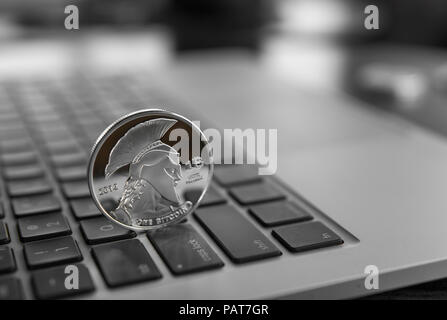 Silber Titan crypto Münze auf einen Laptop Tastatur. Exchange, Business, Werbung. Gewinn aus dem Bergbau crypt Währungen. Bergmann mit astraleums Münze. Stockfoto