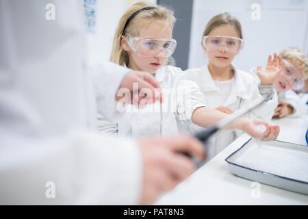 Schülerinnen und Schüler in der Wissenschaft der Klasse beobachten Lehrer experimentieren Stockfoto