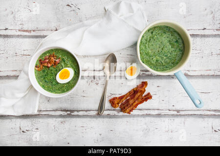 Spinatsuppe mit Ei und Speck Stockfoto