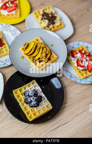 Teller mit Waffeln mit verschiedenen Toppings Stockfoto