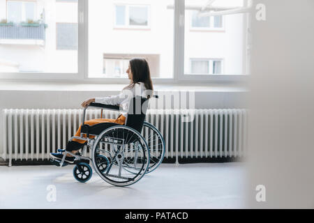 Junge behinderte Frau sitzt im Rollstuhl Stockfoto