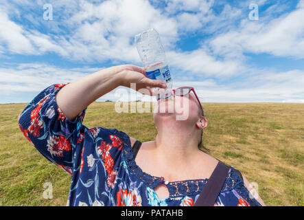 Frau trinkt Wasser aus einer Flasche an einem sehr heißen Sommertag während einer Hitzewelle in Großbritannien im Juli 2018 hydriert zu bleiben. Aktualisiert. Stockfoto