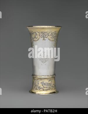 Footed Becher. Kultur: Ungarisch, Brassó. Abmessungen: Insgesamt: 5 3/16 x 2 7/8 in. (13,2 x 7,3 cm). Hersteller: Johannes (Hans) Retsch, Sr. (Master 1608, gestorben 1645). Datum: Erste Hälfte 17. Jahrhundert. Das Erzählen von Geschichten bestückt mit mythologischen Kreaturen - wie die auf der Basis dieser Becher Gravur - war ein beliebter Zeitvertreib bei gesellschaftlichen Anlässen. Teile von Siebenbürgen, der Heimat des Walachischen Fürsten Vlad III Impaler (1431-1476/77), die Inspiration für Bram Stocker's Dracula, wurden angeblich von Drachen und andere sehr gefährliche Kreaturen bewohnt, darunter Flügeldrachen und Leber - essen Adler t Stockfoto