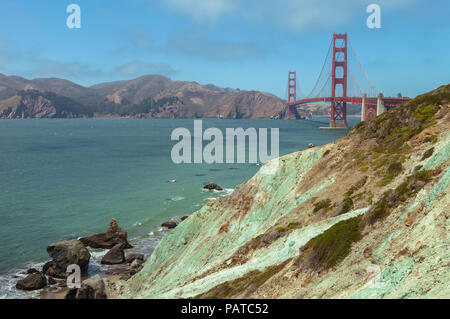 Einzigartige bläulich-grünen serpentinite am Marschall Strand, mit der Golden Gate Bridge im Hintergrund, San Francisco, Kalifornien, USA. Stockfoto