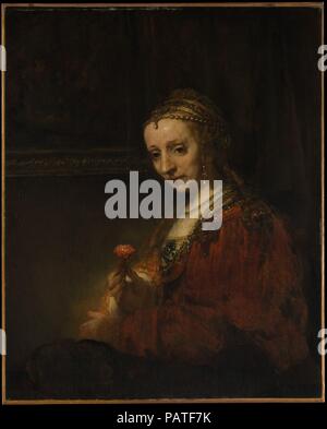 Frau mit einem Rosa. Artist: Rembrandt (Rembrandt van Rijn) (Niederländisch, Leiden 1606-1669 Amsterdam). Abmessungen: 36 1/4 x 29 3/8 in. (92,1 x 74,6 cm). Termin: Anfang 1660 s. Das Tragen eines romantisch veraltete Kostüm und exotischen Schmuck, die Frau hält eine rosa, oder Nelke, Symbol der Liebe und der Ehe. Wenn der Sitter in den Anhänger Portrait, <i>Mann mit einem Vergrößerungsglas</i> (14.40.621) ist Pieter Haringh, dann bescheiden lächelnde Frau ist seine Frau, Elizabeth Delft (Ca. 1620-1679). Über ein Jahrzehnt zuvor das gleiche Paar, das in der konventionellen Kleidung, wurde dargestellt von Rembrandts ehemaliger Schüler Jan Victors (1619-a Stockfoto