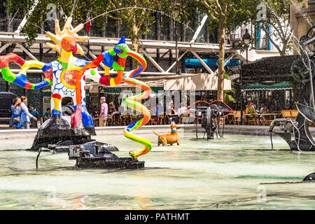 Ein Hund spielt in der strawinsky Brunnen, neben dem Centre Pompidou, Paris, Frankreich Stockfoto