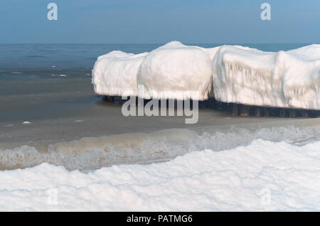 Schnee Wucherungen auf dem Wellenbrecher, Vereisung auf der Wellenbrecher im Meer Stockfoto