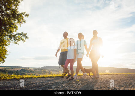 Familie in einem abendlichen Spaziergang mit dem Hund Stockfoto