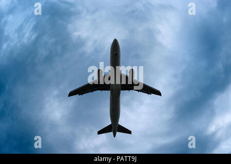 Flugzeug in einem dramatischen stürmischen Himmel, niedrigen Winkel, Vereinigtes Königreich Stockfoto