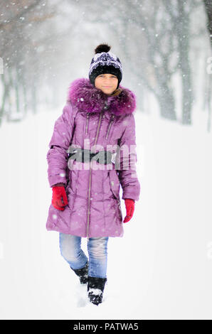 Happy girl Teenager in die purpurroten Mantel im winter. Winter Urlaub Konzept Stockfoto