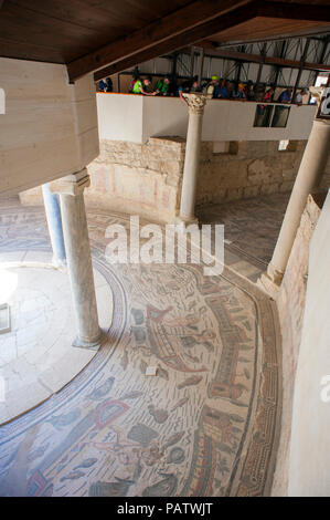 Touristen, die auf der Suche am 4. Jahrhundert Fliesen Mosaik in der Villa Romana del Casale, einer alten römischen Villa außerhalb von Piazza Armerina, Sizilien. Stockfoto