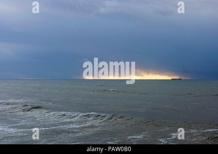 Schiff bei Sonnenuntergang in stürmischen Bedingungen Stockfoto