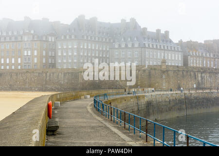 Die ummauerte Stadt Saint-Malo in der Bretagne, Frankreich, von einem nebligen Morgen mit dem Granit Gebäuden im Nebel über der Stadtmauer verschwinden. Stockfoto