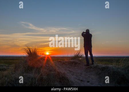 Southport, Merseyside, UK, 14. Juli 2018. Silhouette Menschen. UK Wetter. Farbenfroher Sonnenuntergang über der Irischen See und Ainsdale Sand Dunes National Nature Reserve (NNR), einem 508 Hektar großen Gelände, bestehend aus seltenen Dünen, Strand und Wald Lebensräume. Es gibt 10 km markierte Wanderwege zu folgen, eine ruhige und wilde durch eine der schönsten Städte in England umgeben. Credit: MediaWorldImages/Alamy leben Nachrichten Stockfoto