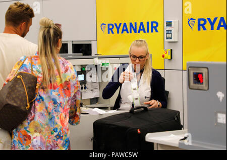 Mallorca, Spanien. 25. Juli 2018, Mallorca, Spanien: Flughafen Mitarbeiter fügt einen Gepäckanhänger zu einem Ryanair Check-in-Schalter am Flughafen Palma de Mallorca. Der Beginn einer zweitägigen Streik der Flugbegleiter in der low-Cost Airline Ryanair die große Unzufriedenheit unter unzähligen Reisenden in mehreren europäischen Ländern verursacht hat. Die meisten Absagen traten in Spanien, wo Ryanair 200 Flüge - knapp ein Viertel der alle Verbindungen abgebrochen. Quelle: dpa Picture alliance/Alamy leben Nachrichten Stockfoto