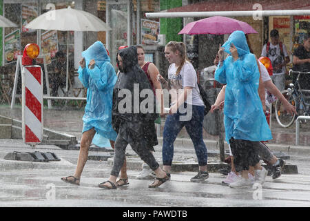 Hamburg, Deutschland. 25. Juli, 2018. Passanten auf der Straße tragen Regenjacken und Schirme. Credit: Bodo Marks/dpa/Alamy leben Nachrichten Stockfoto