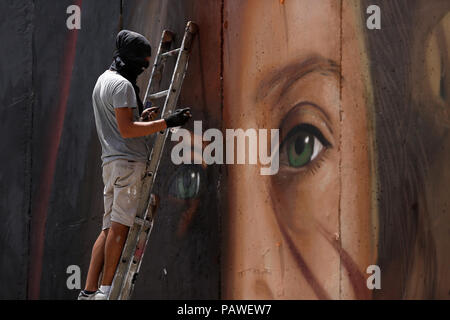 Bethlehem, West Bank. 25. Juli, 2018. Italienische Künstler Jorit Agoch malt ein Wandgemälde mit palästinensischen Jugendlichen Ahed Tamimi auf Israels umstrittenen Trennmauer im Westjordanland Stadt Bethlehem. Tamimi, wurde Anfang des Jahres nach einer viralen Video zeigte ihr zwei Soldaten im besetzten Westjordanland zu schlagen. Credit: Wisam Hashlamoun/APA-Images/ZUMA Draht/Alamy leben Nachrichten Stockfoto