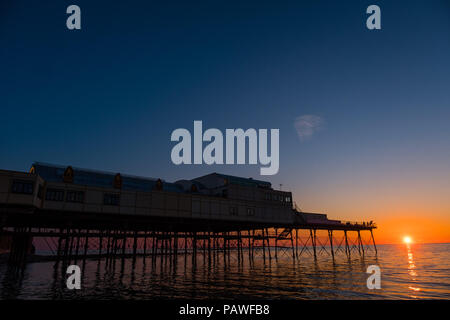 Aberystwyth Wales UK, Mittwoch, 25. Juli 2018 UK Wetter: die Menschen werden durch den herrlichen Sonnenuntergang über Aberystwyth Pier Silhouette am Ende eines Tages des heißen Sommer Sonnenschein. Großbritannien große Hitzewelle fort, mit wenig Erholung von der sehr trockenen Wetter trotz etwas Regen in der Prognose für das Wochenende Foto: Keith Morris/Alamy leben Nachrichten Stockfoto