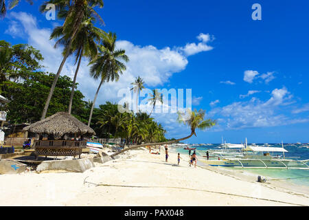 Alona Beach, Bohol, Philippinen - ein gebürtiger Beach Hut mit Blick auf das türkisfarbene Meer und zahlreiche Ausflugsschiffe. Stockfoto