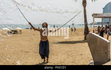 Barcelona, Spanien - 8. Mai 2018: Mann, der eine Menge Seifenblasen auf den Strand Barceloneta in sonniger Tag. Strand Barceloneta in bunte Seifenblasen. Stockfoto