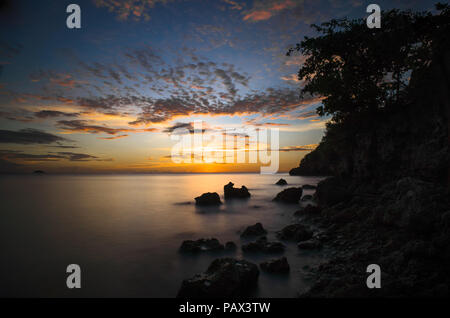 30 Zweite Lange Belichtung Geschossen von Rocky, Tropical Sunset Beach in der Malapascua, Cebu, Philippinen Stockfoto