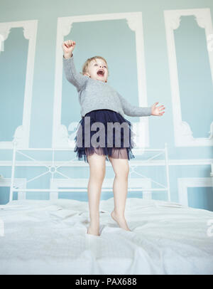 Gerne fünf Jahre altes Mädchen auf dem Bett springen Stockfoto