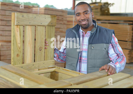 Smily mann Bohr- und Messung von Holz für Deck Stockfoto