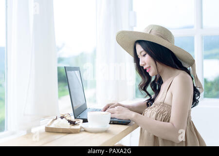 Asiatische Frau Kaffee an für Arbeiten am Laptop im Coffee Shop. Stockfoto