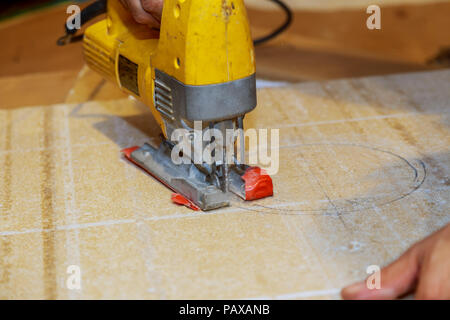 Holz Arbeiter schneiden Holz- Panel mit Stichsäge im Freien, Nahaufnahme der Mann Stockfoto