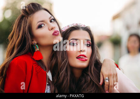 Portrait von hübschen Mädchen mit Frisuren und Make-up, die Gesichter von der Kamera im Freien. Stockfoto