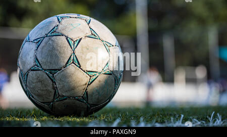 Fußball-Konzept. Ein Fußball Fußball auf das Feld festgelegt, isoliert, mit Kopie der Platz in einem verschwommenen Hintergrund, Tapeten. Stockfoto