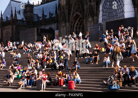 Leute sitzen auf der Treppe bilden die Cathedral Square zum Hauptbahnhof, Köln, Deutschland. Menschen Artikel auf der Treppe von der Domplatte zum Ha Stockfoto