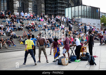 Leute sitzen auf der Treppe bilden die Cathedral Square zum Hauptbahnhof und hören Straßenmusikern, Köln, Deutschland. Menschen Artikel in der Tre Stockfoto